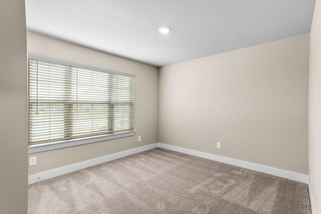 carpeted spare room with baseboards