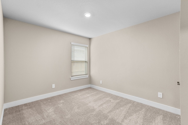 unfurnished room featuring carpet flooring and baseboards