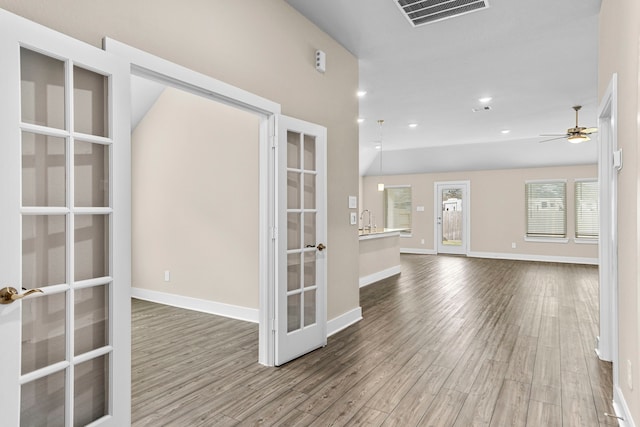 spare room with baseboards, visible vents, wood finished floors, french doors, and recessed lighting