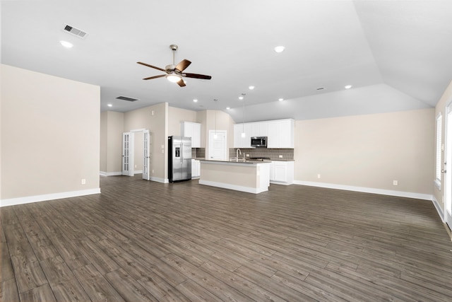 unfurnished living room with dark wood-style floors, visible vents, and a ceiling fan