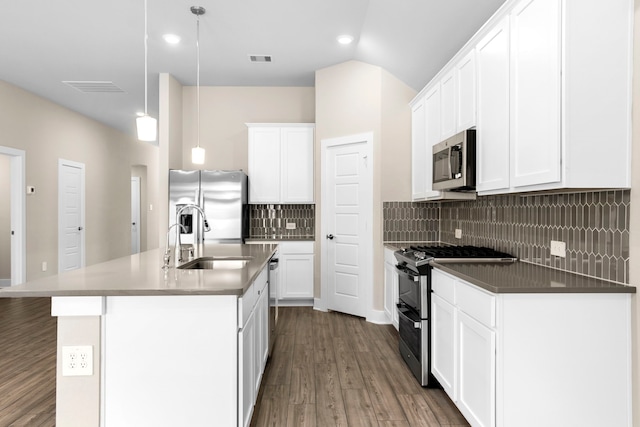 kitchen with visible vents, an island with sink, appliances with stainless steel finishes, dark wood-style flooring, and a sink