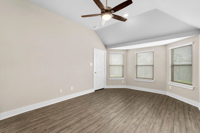 empty room with a ceiling fan, lofted ceiling, dark wood finished floors, and baseboards