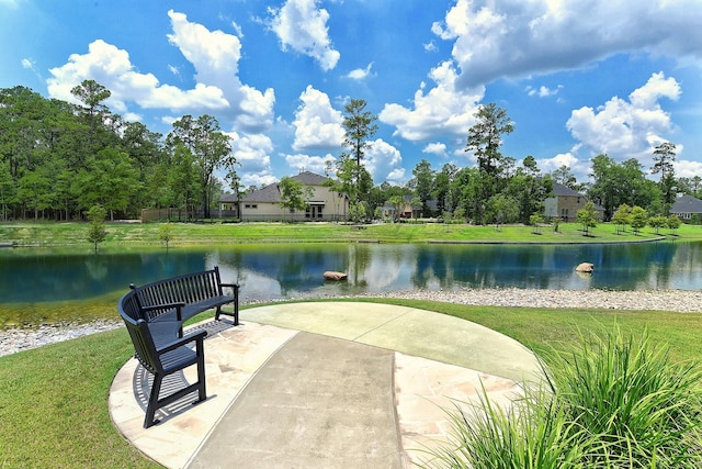 view of home's community with a lawn and a water view