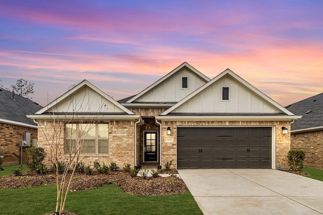 view of front facade with a garage, concrete driveway, a yard, board and batten siding, and brick siding