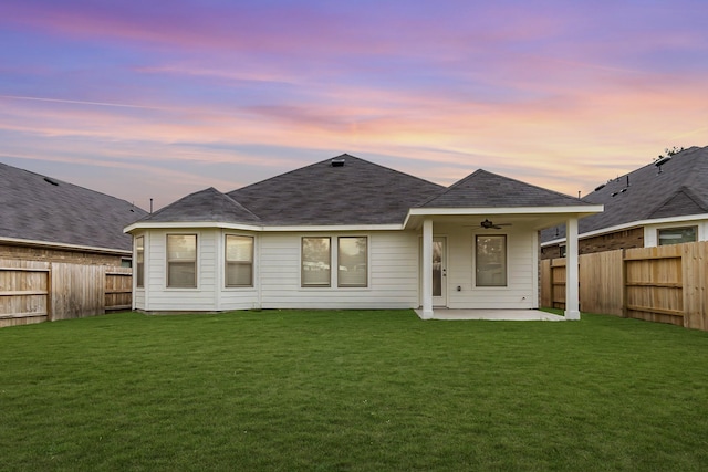 rear view of property featuring a patio area, a fenced backyard, a lawn, and ceiling fan