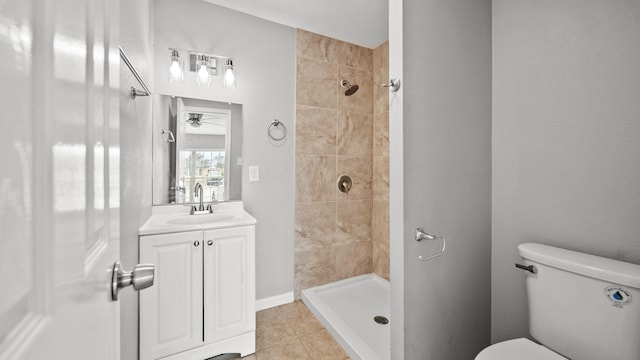 full bathroom featuring tile patterned flooring, a tile shower, vanity, and toilet