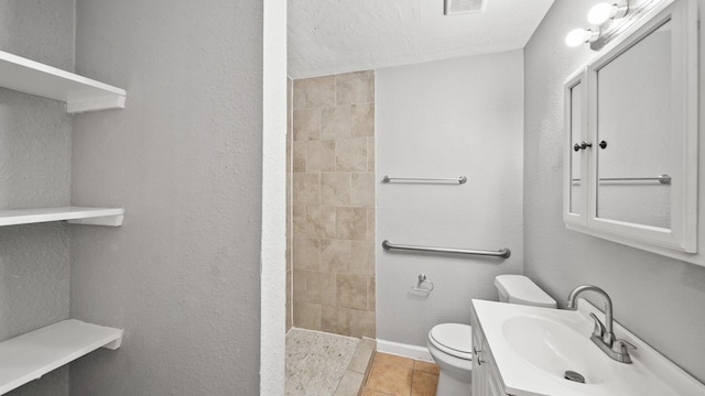 bathroom featuring toilet, a textured wall, walk in shower, and vanity