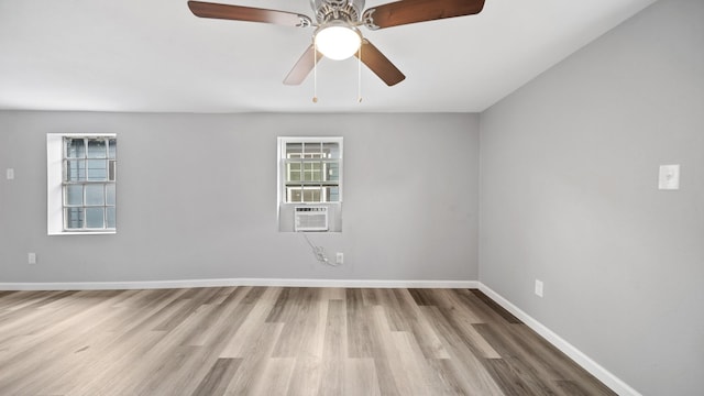 spare room featuring cooling unit, wood finished floors, and baseboards