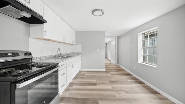 kitchen with under cabinet range hood, a sink, white cabinetry, electric stove, and light wood-type flooring