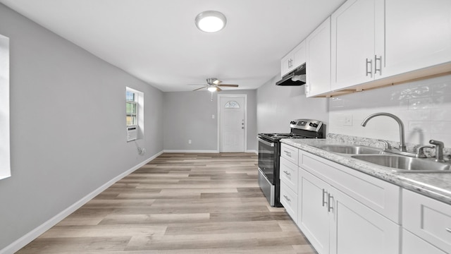 kitchen featuring under cabinet range hood, electric range, a sink, white cabinetry, and light countertops