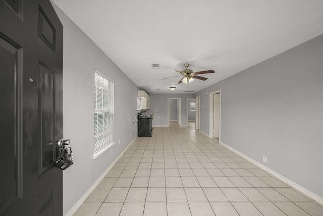 unfurnished living room featuring baseboards, visible vents, a ceiling fan, and light tile patterned flooring