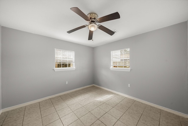 spare room featuring light tile patterned flooring, ceiling fan, and baseboards