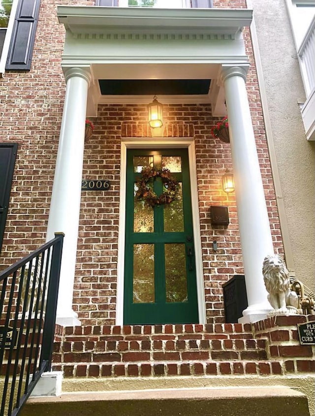 entrance to property featuring brick siding