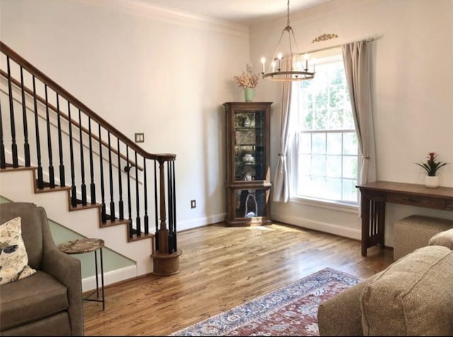 entryway with a chandelier, wood finished floors, baseboards, stairs, and ornamental molding