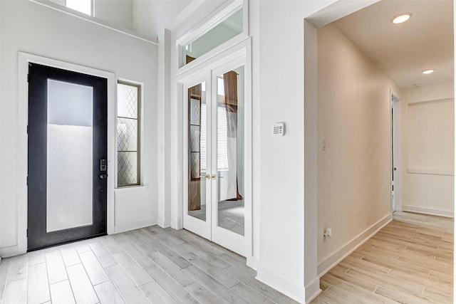 entryway with recessed lighting, french doors, light wood-style flooring, and baseboards