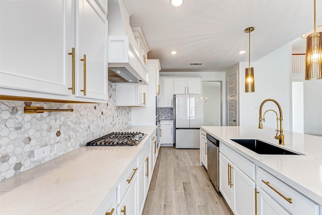 kitchen with stainless steel appliances, visible vents, white cabinetry, a sink, and light wood-type flooring