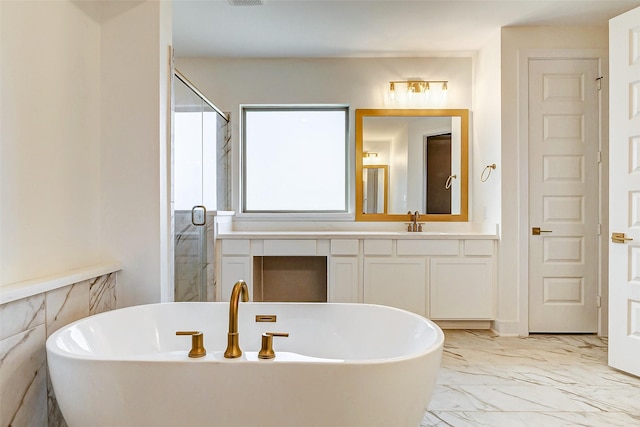 bathroom with a stall shower, marble finish floor, a soaking tub, and vanity