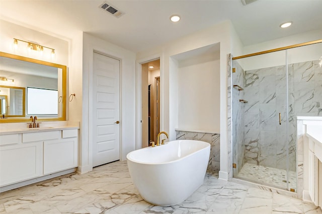 bathroom with marble finish floor, a marble finish shower, a freestanding bath, and vanity