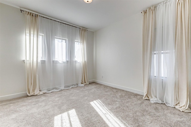 carpeted spare room featuring baseboards