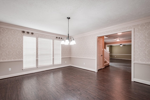 unfurnished dining area featuring dark wood-style floors, ornamental molding, wainscoting, a textured ceiling, and wallpapered walls