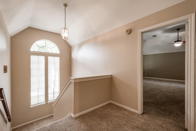 stairs featuring vaulted ceiling, ceiling fan, carpet flooring, and baseboards