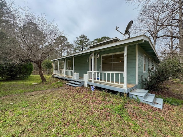 view of front of home featuring covered porch and a front lawn