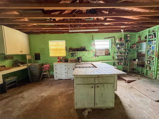 miscellaneous room featuring cooling unit, concrete floors, and a workshop area