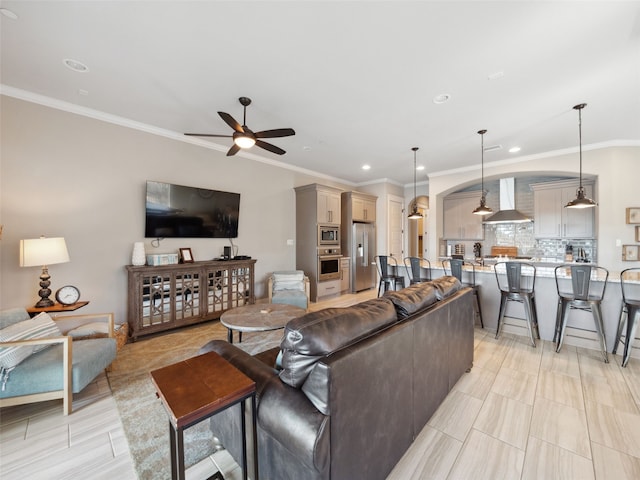 living room featuring ornamental molding, arched walkways, a ceiling fan, and recessed lighting