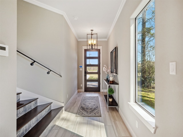 entryway with crown molding, wood finish floors, baseboards, stairs, and an inviting chandelier