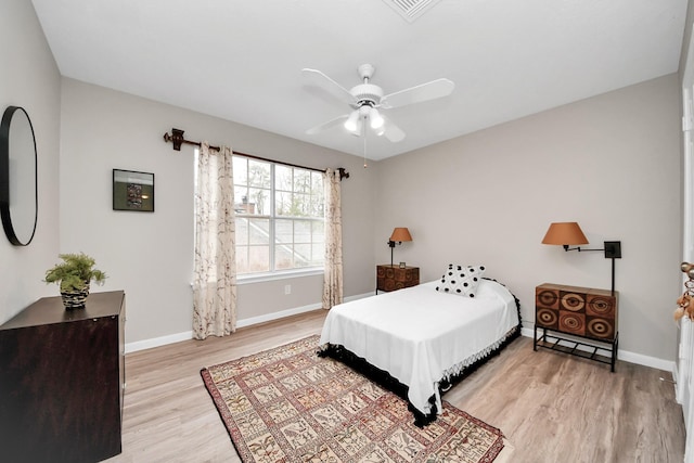 bedroom with a ceiling fan, visible vents, light wood-style flooring, and baseboards