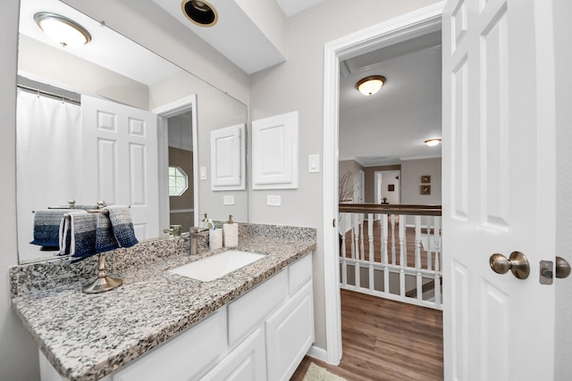 bathroom with vanity, baseboards, and wood finished floors