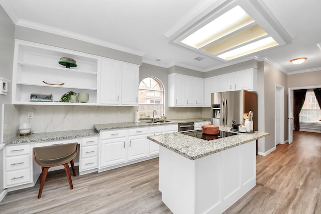 kitchen with crown molding, stainless steel appliances, white cabinetry, a sink, and light wood-type flooring