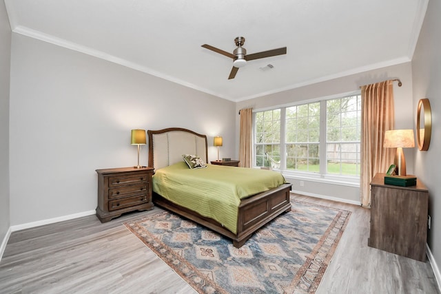 bedroom with visible vents, ornamental molding, a ceiling fan, wood finished floors, and baseboards