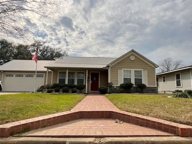 single story home featuring a garage, metal roof, a front yard, and driveway