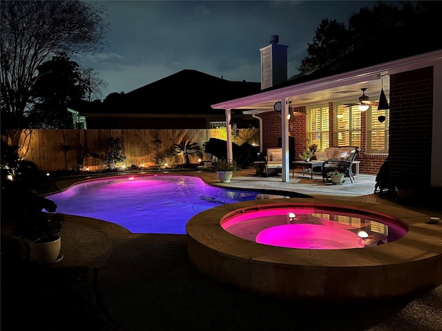 pool at twilight with a fenced in pool, a fenced backyard, an in ground hot tub, a patio area, and an outdoor living space