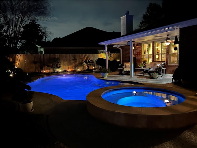 pool at twilight featuring a fenced in pool, an outdoor hangout area, an in ground hot tub, fence, and a patio area