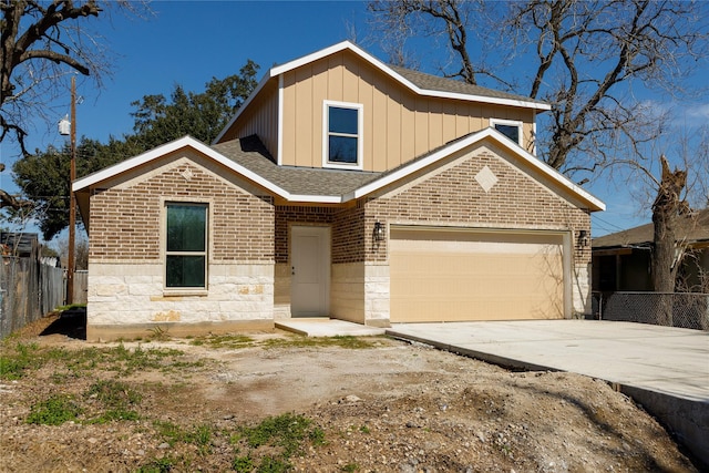 view of front of property with driveway, a shingled roof, fence, board and batten siding, and brick siding