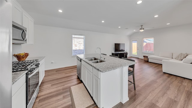 kitchen with open floor plan, appliances with stainless steel finishes, a sink, and recessed lighting