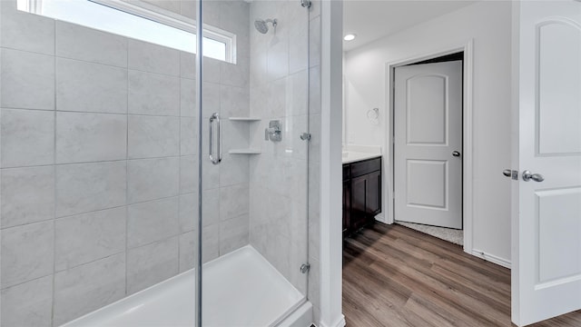 full bathroom with a stall shower, vanity, and wood finished floors