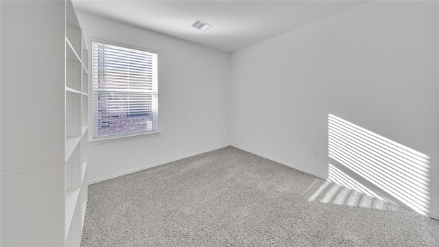 carpeted spare room featuring visible vents and baseboards