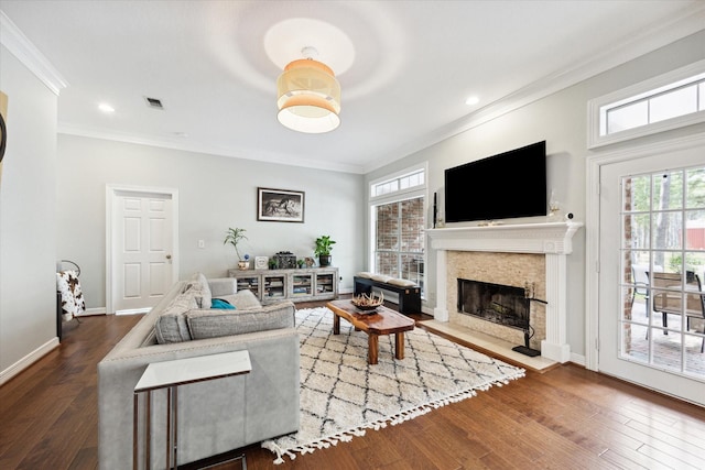 living room featuring crown molding, visible vents, a high end fireplace, wood finished floors, and baseboards