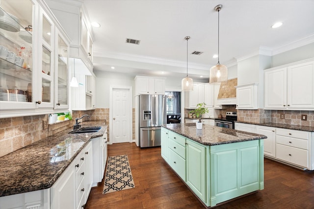 kitchen featuring stainless steel appliances, a sink, visible vents, and white cabinets