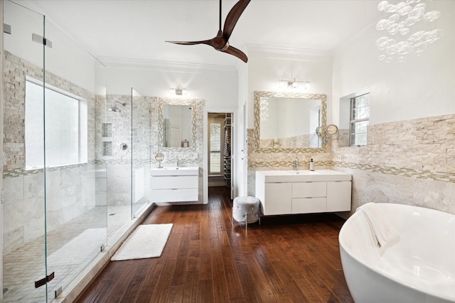 bathroom featuring a soaking tub, a shower stall, hardwood / wood-style flooring, and tile walls