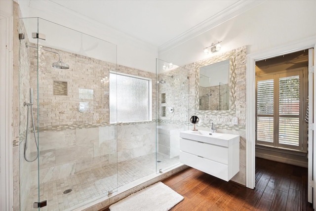 full bathroom with a stall shower, wood finished floors, vanity, and crown molding