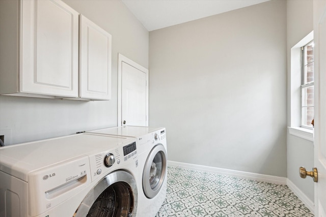 laundry area featuring cabinet space, baseboards, light floors, and washer and dryer