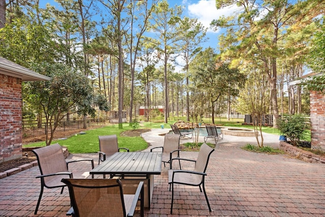 view of patio / terrace with outdoor dining space, fence, and a fire pit