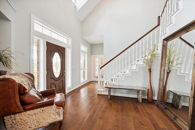 foyer with dark wood-style flooring, baseboards, a high ceiling, and stairs