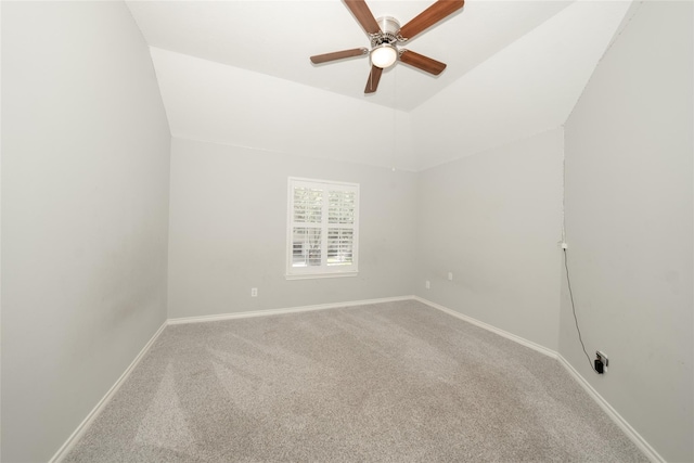 carpeted empty room with ceiling fan, baseboards, and vaulted ceiling