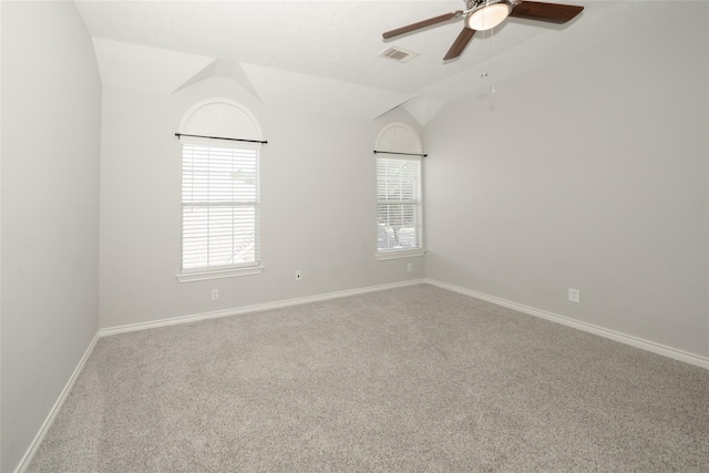 spare room featuring lofted ceiling, baseboards, visible vents, and a healthy amount of sunlight