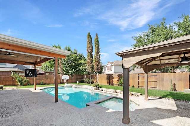 view of swimming pool featuring a patio area, a fenced backyard, and a pool with connected hot tub